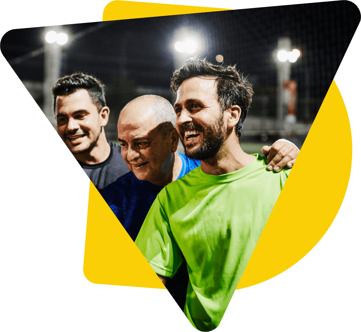 Three men smiling at an outdoor team sports event at night 